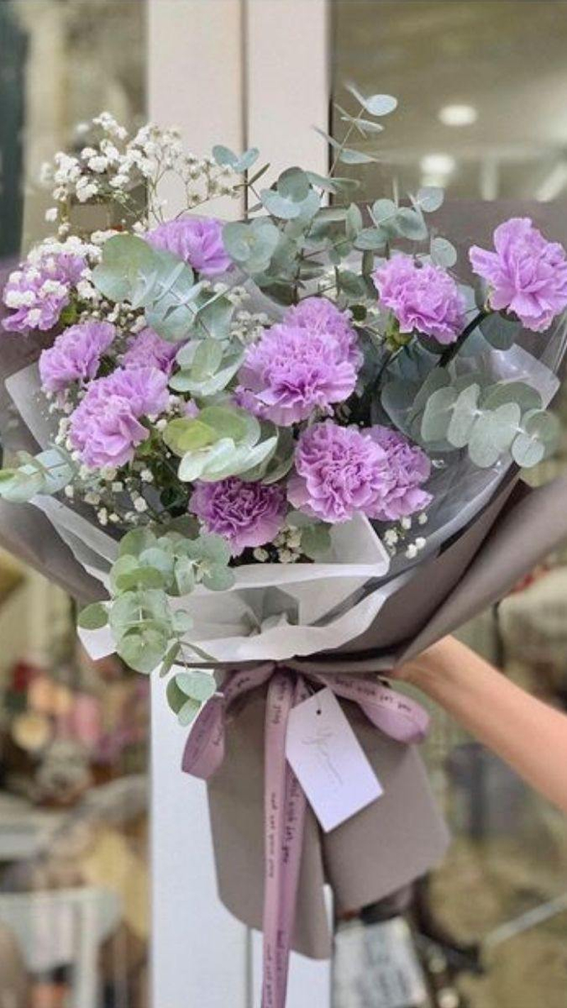 Bó hoa cẩm chướng tím phối cùng lá bạc tạo vẻ dịu dàng, thích hợp dành tặng mẹ hoặc bà. (Nguồn: Internet)