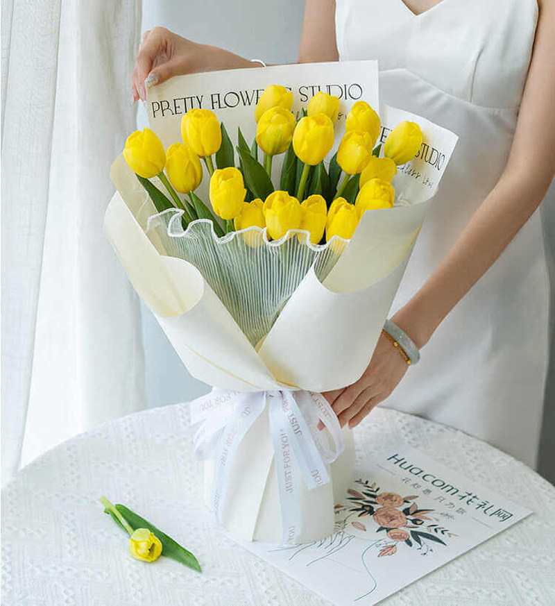 Bó tulip vàng gói giấy trắng mang vẻ đẹp tối giản, phù hợp với người yêu thích sự tinh tế. (Nguồn: Internet)