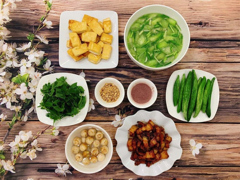 Mâm cơm gia đình với thịt kho trứng, rau xào và bát canh nóng (Nguồn: Internet)