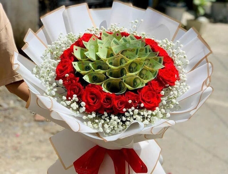 Bó hoa hồng đỏ kết hợp hoa tiền tạo thiết kế độc đáo, thu hút ánh nhìn. (Nguồn: Internet)