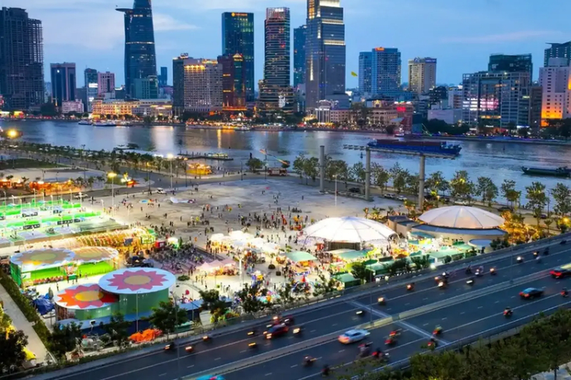 People relax and view the city center from the Saigon Riverfront Park in Thủ Thiêm. (Source: Internet)