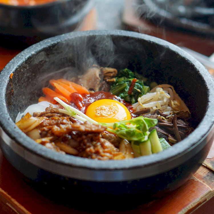 Bibimbap là món cơm trộn với sự kết hợp giữa đa dạng nguyên liệu như cà rốt, dưa leo, nấm xào, trứng ốp la và thịt bò, tương ớt