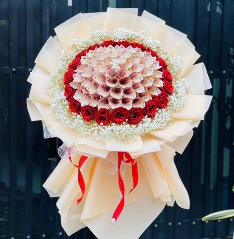 Bó hoa tiền kết hợp hoa hồng đỏ được gói trong giấy màu kem, tạo hình nổi bật và khác biệt. (Nguồn: Internet)
