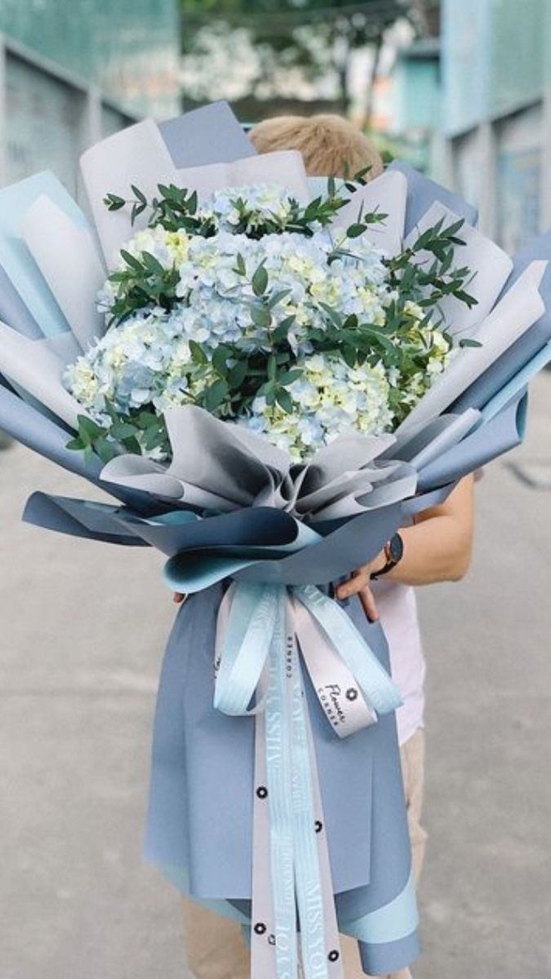 Bó hoa trắng xanh được gói giấy xanh nhạt, mang vẻ thanh lịch và trang nhã. (Nguồn: Internet)