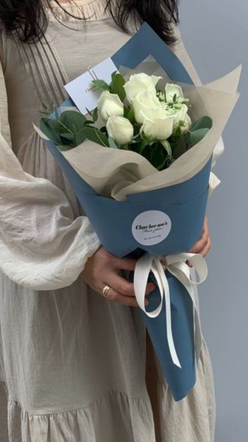 Bó hoa hồng trắng gói giấy xanh là món quà nhẹ nhàng, phù hợp dành tặng cấp trên hoặc khách hàng. (Nguồn: Internet)