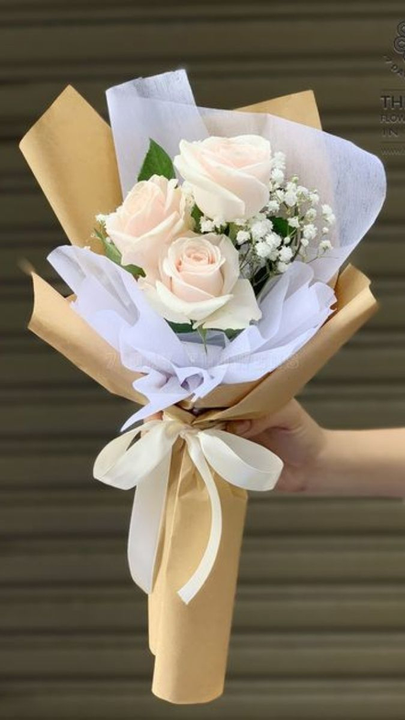 Bó hoa hồng trắng phối baby trắng, gói giấy màu kem, phù hợp dành tặng đồng nghiệp dịp 20/10. (Nguồn: Internet)