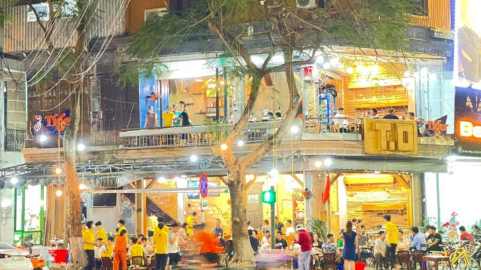 Quán Bò Tơ Quán Mộc tại Hà Nội về đêm với không gian mở, đông khách và ánh đèn vàng ấm áp.