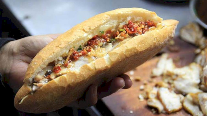 Bánh mì Chị Đấu trứ danh, một món ăn đường phố ngon tuyệt với nhân thịt hấp dẫn, đang được chuẩn bị để phục vụ.
