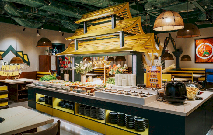 Quầy buffet lẩu tự chọn với nhiều loại rau xanh, nấm tươi, đậu hũ và các loại viên thả lẩu được bày trí đẹp mắt dưới mái nhà gỗ cách điệu.