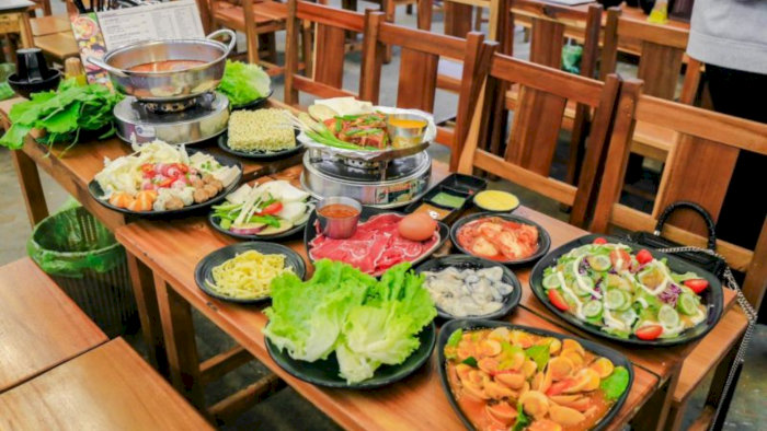 Bàn ăn tại Lộc Cóc Quán ở Hà Nội với lẩu riêu cua bắp bò và nhiều món ăn kèm hấp dẫn.