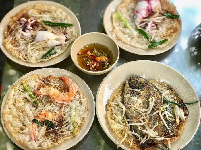 Bánh xèo hải sản đa dạng, với tôm, mực, cá tươi ngon, giòn rụm, kèm nước chấm hấp dẫn.