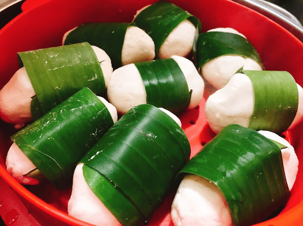 Những chiếc bánh sắn nhỏ xinh, màu trắng đục được gói trong những miếng lá chuối xanh mướt đang được hấp trong xửng hấp màu đỏ, một món ăn dân dã đặc trưng của Việt Nam
