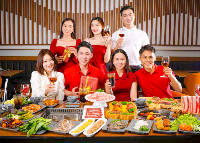 Nhóm bạn trẻ rạng rỡ thưởng thức tiệc buffet nướng thịnh soạn trong không gian nhà hàng sang trọng.