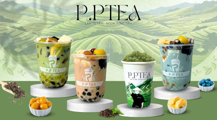 Bốn cốc trà sữa P.P Tea hấp dẫn với trân châu, thạch và trái cây trên nền đồi chè xanh mướt.