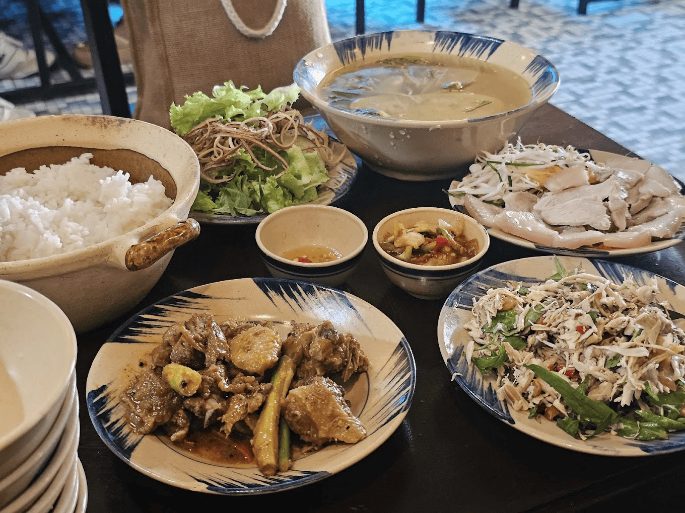 Mâm cơm bình dị mà hấp dẫn, đầy đủ tại Cơm hẻm 134 Bàn ăn với nồi cơm trắng, bát canh rau, đĩa thịt kho, gỏi trộn và rau sống, bữa cơm nhà giản dị mà ngon miệng