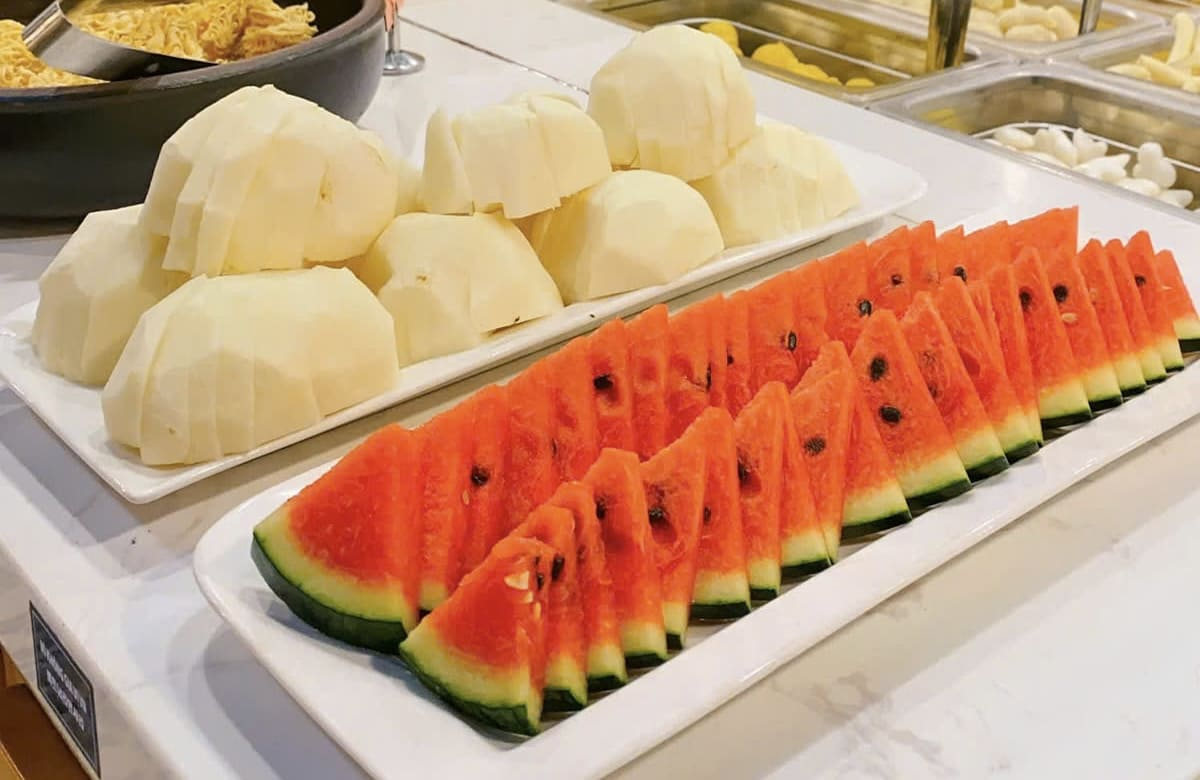 Hai đĩa trái cây tươi ngon với những miếng dưa hấu đỏ mọng được cắt tỉa đẹp mắt và những miếng dứa vàng ươm hấp dẫn.