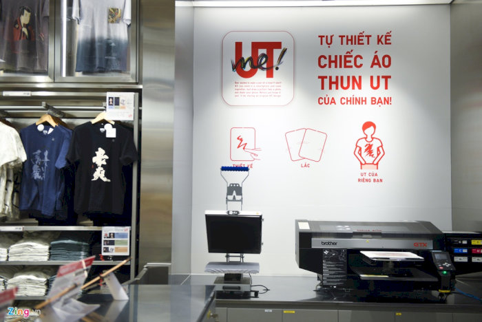 Khu vực thiết kế &aacute;o thun UT c&aacute; nh&acirc;n h&oacute;a tại cửa h&agrave;ng UNIQLO, với m&aacute;y in, m&agrave;n h&igrave;nh vi t&iacute;nh v&agrave; hướng dẫn tạo &aacute;o UT của ri&ecirc;ng bạn tr&ecirc;n tường.