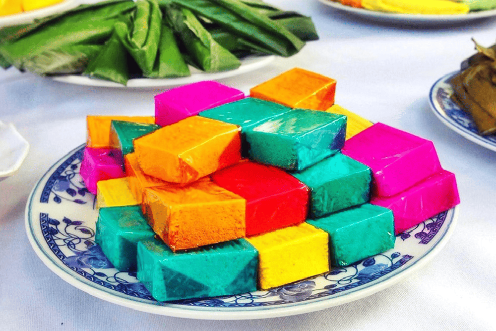 Đĩa bánh in truyền thống của Việt Nam với nhiều màu sắc tươi tắn như hồng, xanh lá, vàng, cam và đỏ được xếp chồng lên nhau trên chiếc đĩa sứ