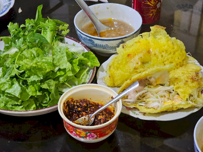 Bánh xèo vàng ươm giòn rụm, kèm rau sống tươi xanh và chén nước chấm đậm đà, chuẩn vị bữa ăn Việt.